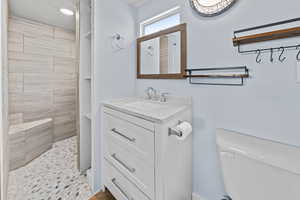 Bathroom with tiled shower and vanity