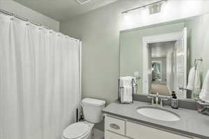 Full bathroom featuring vanity, a shower with shower curtain, and a textured ceiling