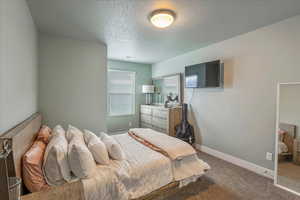Bedroom with carpet floors and a textured ceiling
