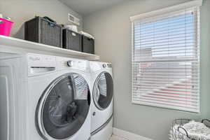 Laundry room with separate washer and dryer and baseboards
