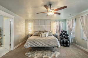 Carpeted bedroom featuring a ceiling fan and a textured ceiling