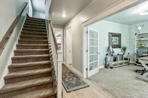 Stairway with wood finished floors and carpet