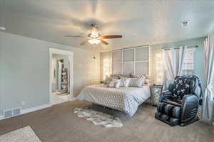 Bedroom with a textured ceiling, carpet flooring, and ceiling fan