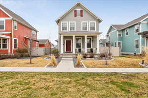 View of front of house with covered porch, stucco siding, and a gate