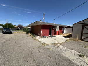 Rear view of house featuring brick siding and a storage shed