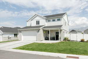 Traditional-style home with a gate, driveway, brick siding, and an attached garage