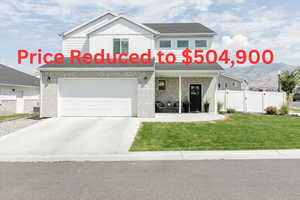 View of front of home featuring a porch, a gate, driveway, brick siding, and an attached garage