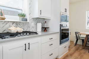 Kitchen with stainless steel appliances and white cabinetry,
