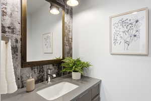 Bathroom featuring vanity and backsplash