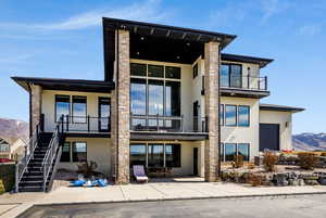 Back of house with a mountain view and stucco siding