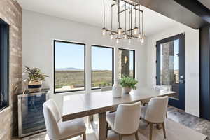 Dining room with wood finished floors, beverage cooler, hanging lights, and a mountain view