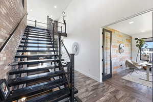 Stairway featuring wood finished floors, recessed lighting, and an accent wall