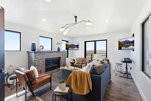 Living room with dark wood-style floors, a fireplace, and recessed lighting