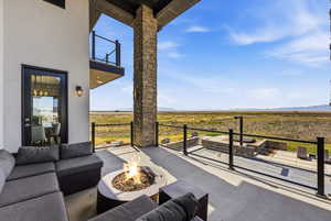 View of patio featuring an outdoor living space with a fire pit and a mountain view
