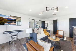 Living area featuring dark wood-style flooring and recessed lighting
