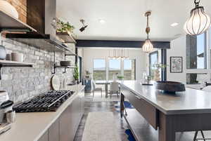 Kitchen with open shelves, tasteful backsplash, black gas cooktop, dark wood-style flooring, and hanging light fixtures