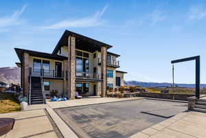 Back of house featuring a mountain view, stucco siding, and a balcony