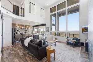Living area featuring recessed lighting, a high ceiling, and dark wood-style floors