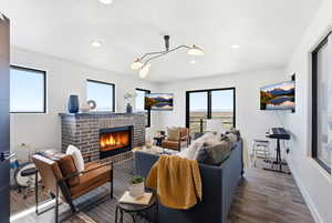 Living room with dark wood finished floors, a fireplace, and recessed lighting