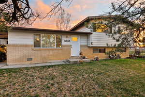 Tri-level home featuring brick siding and a front lawn
