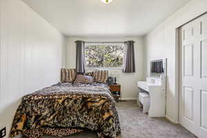 Bedroom featuring light carpet and baseboards