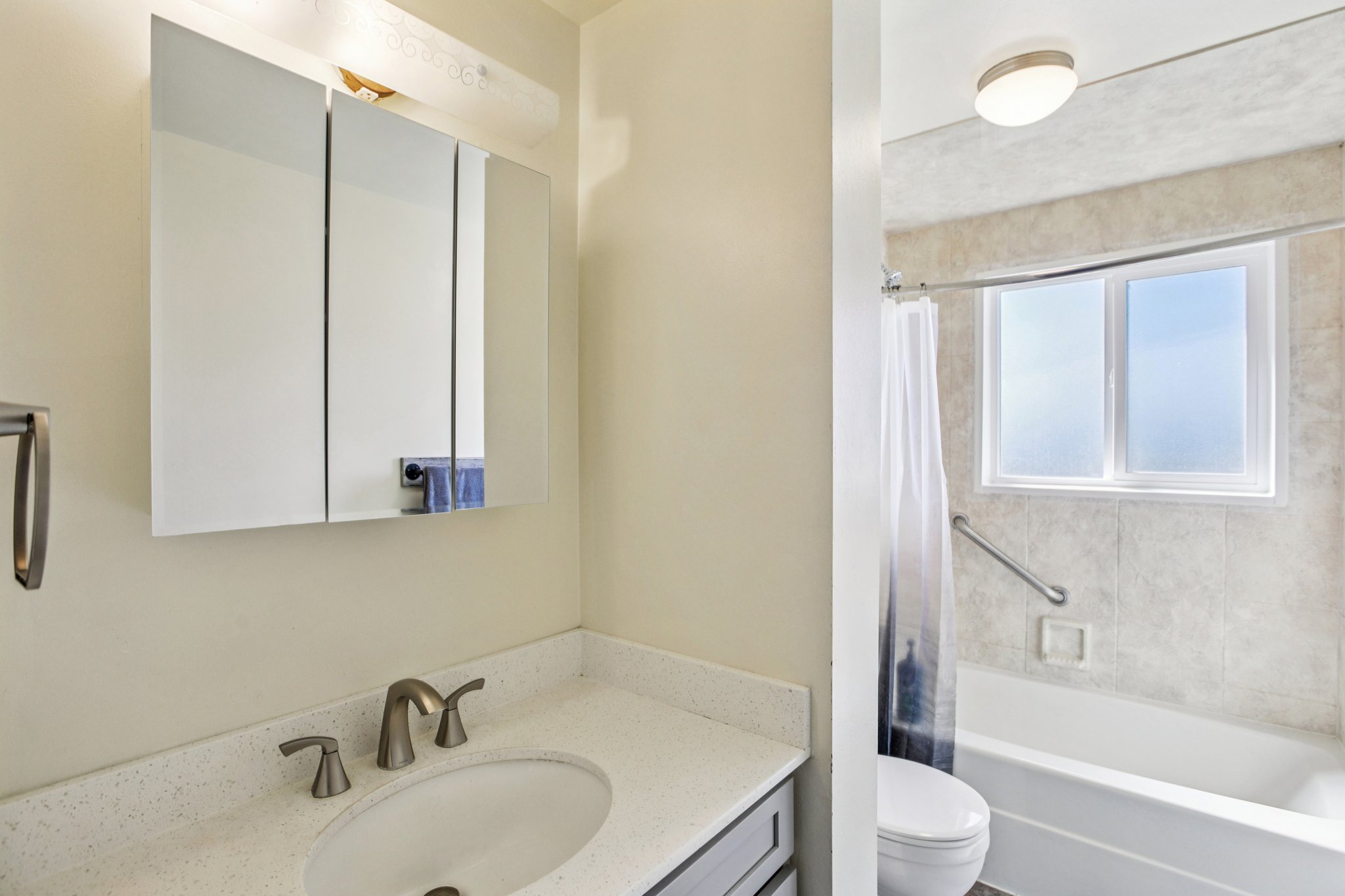 Bathroom featuring vanity and shower / bath combination with curtain
