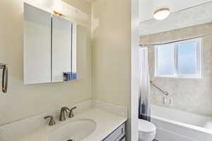 Bathroom featuring vanity and shower / bath combination with curtain
