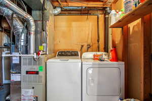 Laundry area with heating unit and washer and clothes dryer
