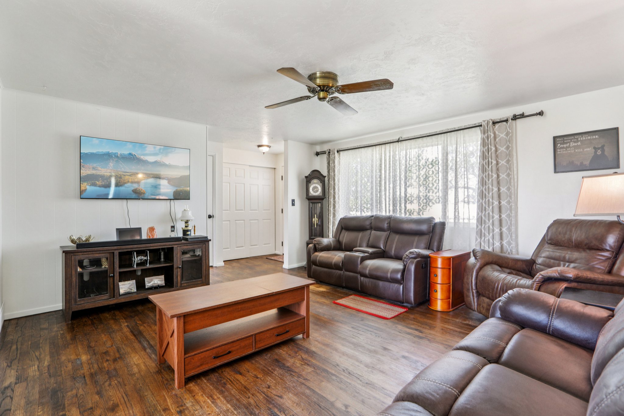 Living area featuring wood finished floors and a ceiling fan