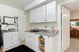 Kitchen featuring white cabinets and light stone countertops