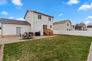 Rear view of house featuring a patio area, a fenced backyard, and roof with shingles