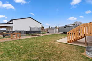 Fenced backyard with a shed and a trampoline
