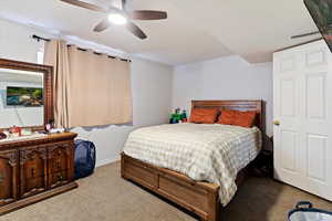 Carpeted bedroom with a ceiling fan and baseboards