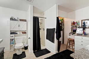 Full bathroom with vanity, a stall shower, a textured ceiling, light tile patterned floors, and washer / clothes dryer