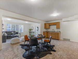Dining room featuring light colored carpet and baseboards
