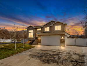 Contemporary two-story residence featuring a two-car garage, stone facade accents, and a concrete driveway