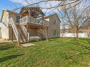 Rear view of house with a wooden deck and stairs
