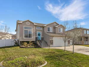 View of front of house with stucco siding, a garage, driveway, stone siding, and roof with shingles