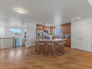 Kitchen featuring a kitchen bar, wood finish cabinetry, and light stone counters