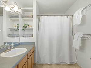 Full primary ensuite bathroom with vanity, shower / tub combo