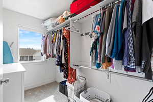 Walk in closet with light colored carpet