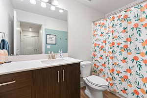 Full bathroom with vanity, a shower with shower curtain, and light wood finished floors