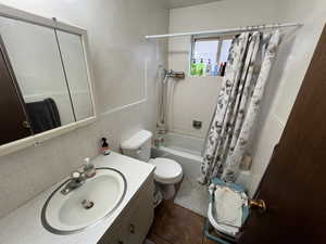 Full bath with vanity, shower / bath combination with curtain, and tile walls