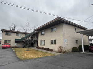 View of home's exterior featuring stairway and a yard