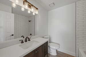 Full bathroom with vanity, dark wood finished floors, and shower / washtub combination