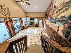 Kitchen featuring a fireplace, a ceiling fan, light floors, vaulted ceiling, and recessed lighting