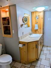 Bathroom with a textured ceiling and vanity