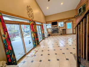 Unfurnished living room featuring lofted ceiling, recessed lighting, a stone fireplace, and light floors