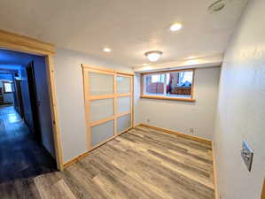 Unfurnished bedroom featuring wood finished floors, recessed lighting, a textured wall, and a textured ceiling