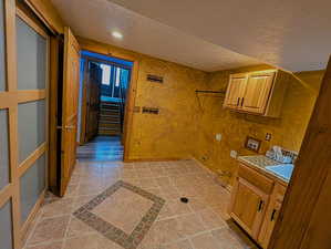 Laundry room featuring washer hookup, a textured ceiling, and cabinet space